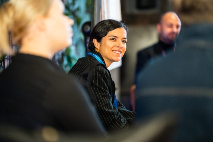 Työryhmän jäsen kuuntelee ja hymyilee